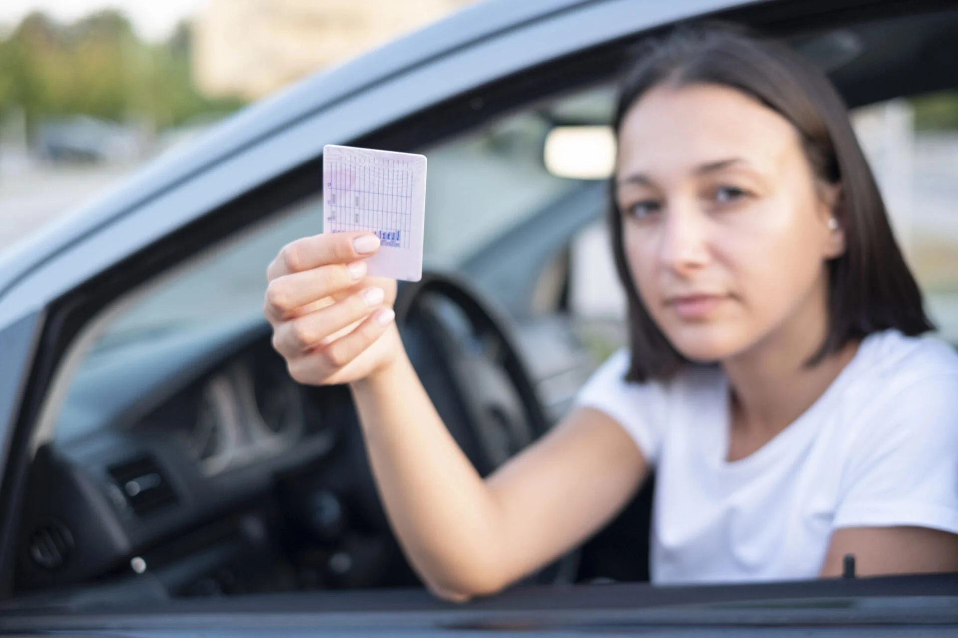 Female driver holding up an ID card