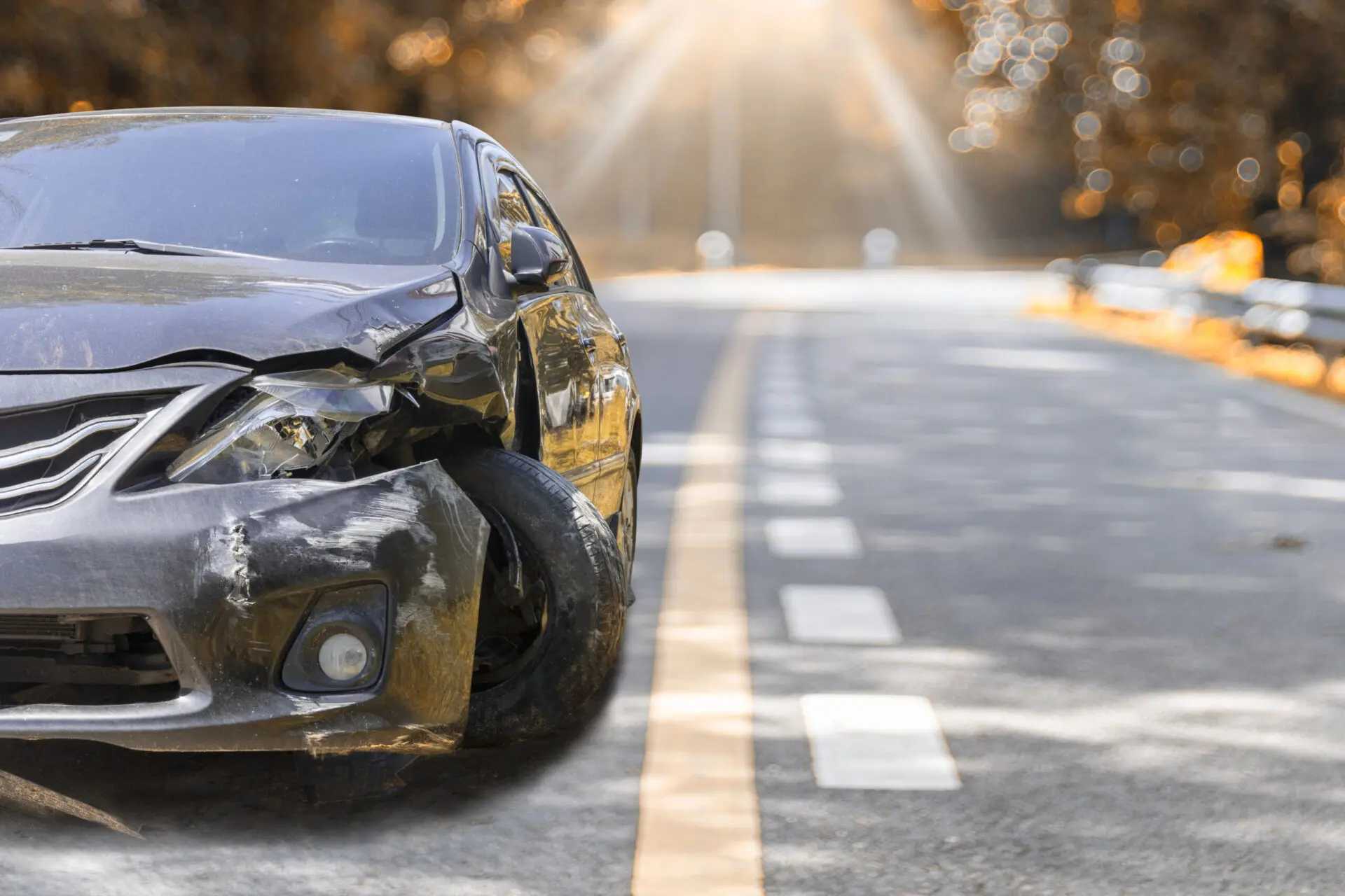 A black vehicle sits in the road with a smashed in front end