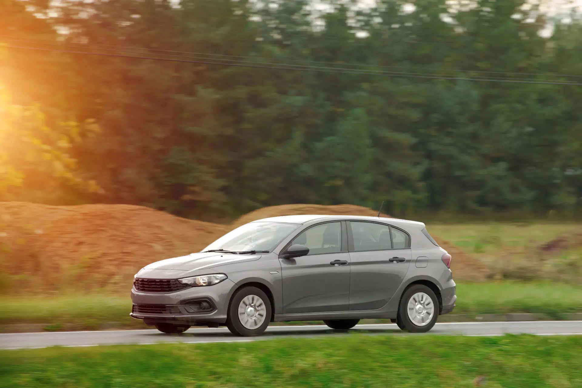 Silver car driving on street with blurred background